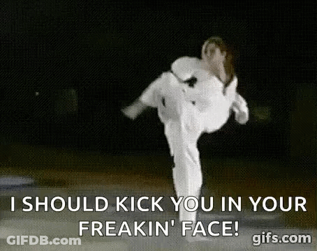 A Woman In A White Karate Uniform Is Kicking A Man In The Face . GIF
