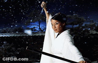 A Woman In A White Kimono Holds A Sword In The Snow GIF