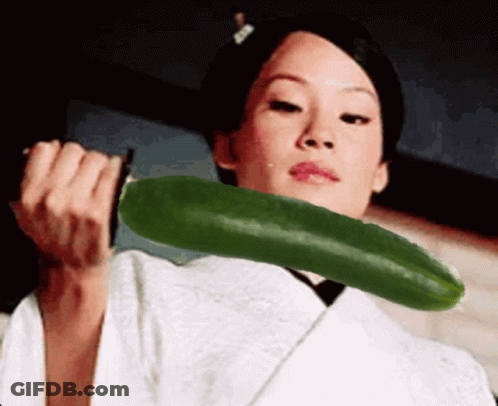 A Woman In A White Kimono Is Holding A Green Cucumber In Her Hands GIF