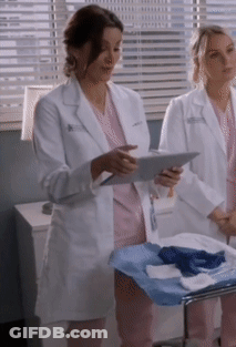 A Woman In A White Lab Coat Holds A Tablet GIF