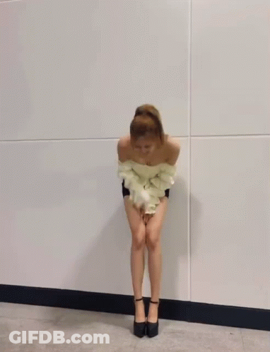A Woman In A White Off The Shoulder Top And Shorts Is Dancing . GIF