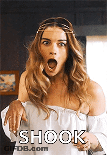 A Woman In A White Off The Shoulder Top Is Making A Surprised Face With The Word Shook Written Below Her . GIF