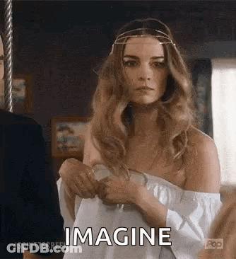 Woman In White Off-Shoulder Top Standing Next To Man In Suit GIF