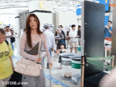 Woman With White Purse Walking Through Airport GIF