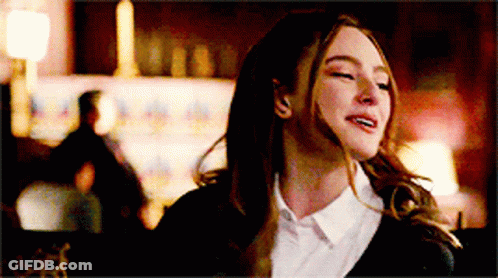 A Woman In A White Shirt And Black Jacket Is Laughing With Her Eyes Closed . GIF
