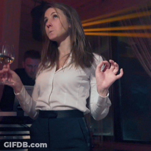 A Woman In A White Shirt Holds A Glass Of Wine In Front Of A Yamaha Keyboard GIF