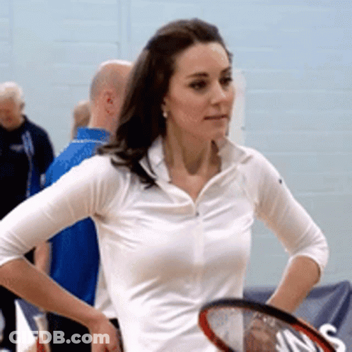 A Woman In A White Shirt Holds A Tennis Racquet In Her Hand GIF