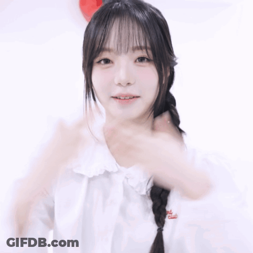 A Woman In A White Shirt Holds Her Hands To Her Chest GIF