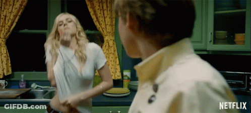 A Woman In A White Shirt Is Dancing In A Kitchen With A Netflix Logo GIF