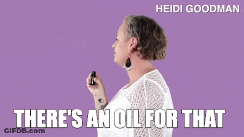 A Woman In A White Shirt Is Holding A Bottle Of Oil . GIF