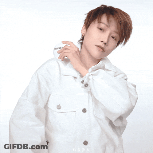 A Woman In A White Shirt Is Holding A Christian Dior Container GIF
