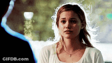A Woman In A White Shirt Is Looking At A Man . GIF