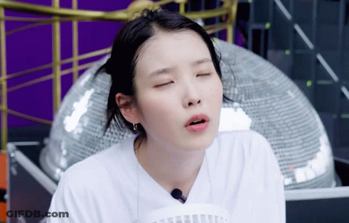 A Woman In A White Shirt Is Making A Face With Her Eyes Closed GIF