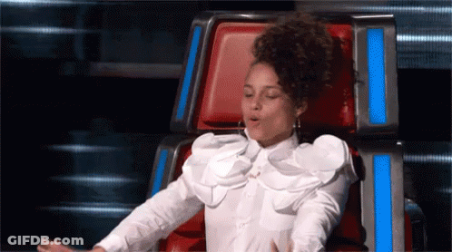 A Woman In A White Shirt Is Sitting In A Chair With Her Mouth Open GIF