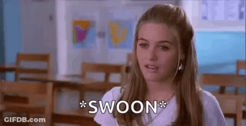 A Woman In A White Shirt Is Sitting In A Classroom And Making A Funny Face . GIF