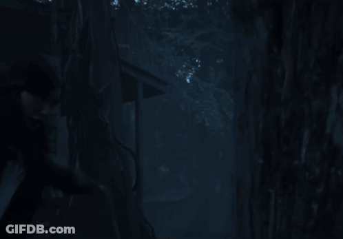 A Woman In A White Shirt Is Standing In Front Of A Glass Wall GIF