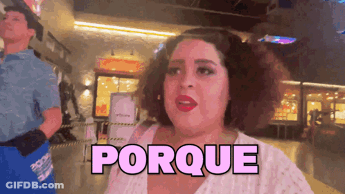 A Woman In A White Shirt Is Standing In Front Of A Sign That Says " Porque " GIF