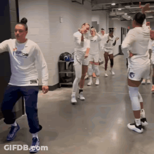 A Woman In A White Shirt That Says Pride Is Dancing GIF