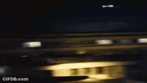 A Woman In A White Shirt With A Hole In It Is Standing In A Dark Room . GIF