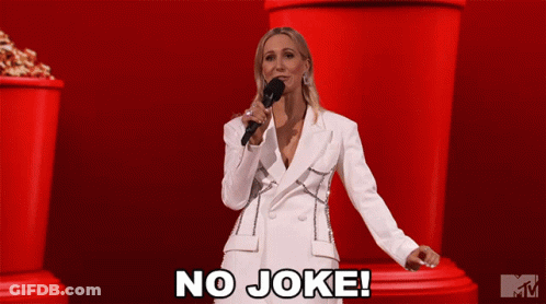 A Woman In A White Suit Is Holding A Microphone And Says " No Joke " GIF