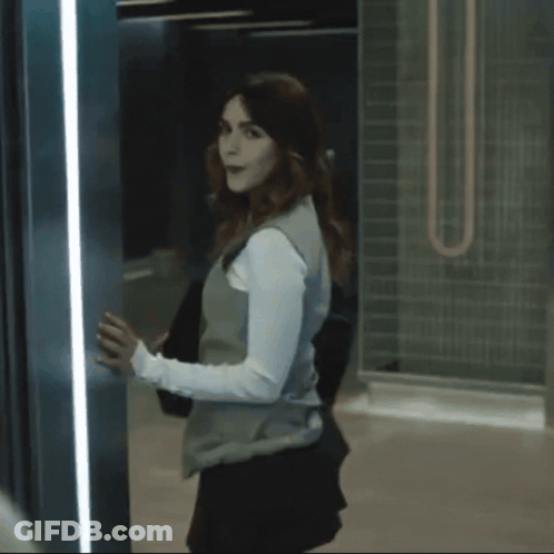 A Woman In A White Suit Is Standing In An Elevator And Says Thank You Mommy GIF