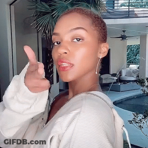 A Woman In A White Sweater Giving A Thumbs Up Sign GIF