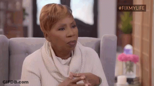A Woman In A White Sweater Is Sitting In A Chair And Making A Funny Face . GIF