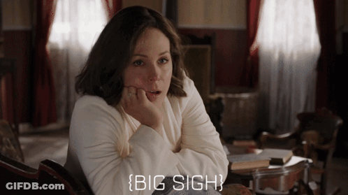 A Woman In A White Sweater Is Sitting In A Chair With Her Hand On Her Chin And The Words Big Sigh Below Her GIF