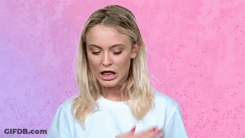 A Woman In A White T-Shirt Is Making A Funny Face . GIF