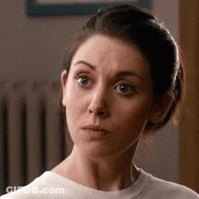 A Woman In A White T-Shirt Is Making A Funny Face . GIF