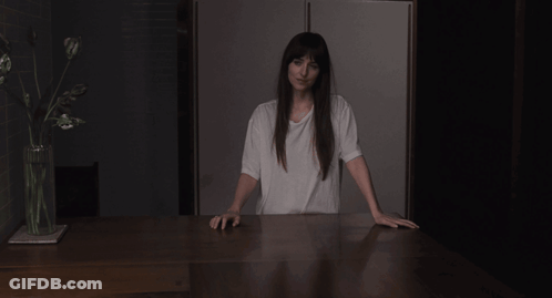 A Woman In A White T-Shirt Is Pointing At Her Chest GIF