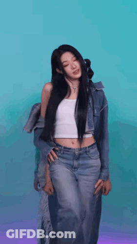 A Woman In A White Tank Top And Jeans Is Standing In Front Of A Blue And Purple Background . GIF