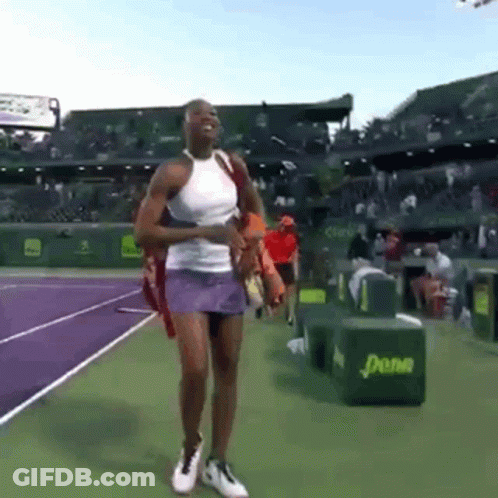 A Woman In A White Tank Top And Purple Skirt Is Walking On A Tennis Court .. GIF