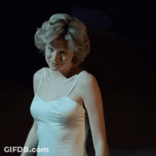 A Woman In A White Tank Top Is Smiling GIF