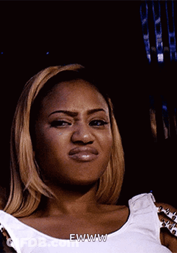 A Woman In A White Tank Top Says Ewww On Her Face GIF