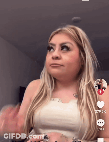 A Woman In A White Top Has A Tattoo Of A Heart On Her Arm GIF