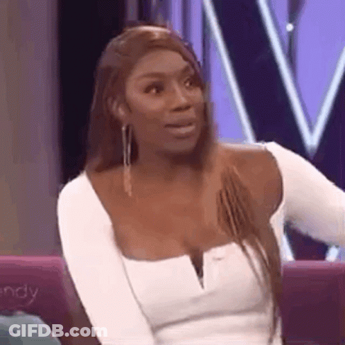 A Woman In A White Top Is Sitting On A Couch . GIF