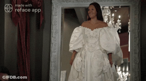 A Woman In A White Wedding Dress Is Standing In Front Of A Mirror With The Words Made With Reface App On The Bottom GIF