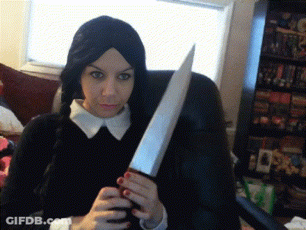 A Woman In A Wig Holds A Large Knife In Her Hands GIF