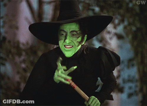 A Woman In A Witch Costume Is Holding A Broom With Gw Written In The Corner GIF