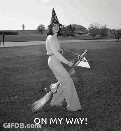 A Woman In A Witch Hat Is Flying On A Broom With The Words On My Way Written Below Her GIF