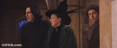 A Woman In A Witch Hat Is Standing Next To A Man GIF