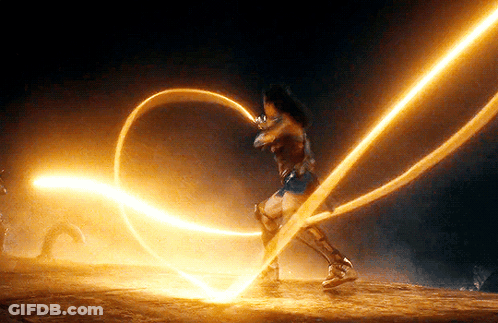 A Woman In A Wonder Woman Costume Is Holding A Glowing Rope . GIF