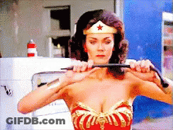 A Woman In A Wonder Woman Costume Is Holding A Whip In Her Hands GIF