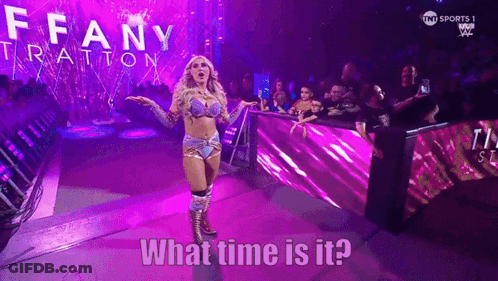 A Woman In A Wrestling Outfit Is Standing In Front Of A Crowd And Says What Time Is It .. GIF