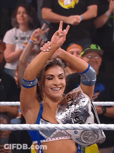 A Woman In A Wrestling Ring Holds A L2 Championship Belt GIF