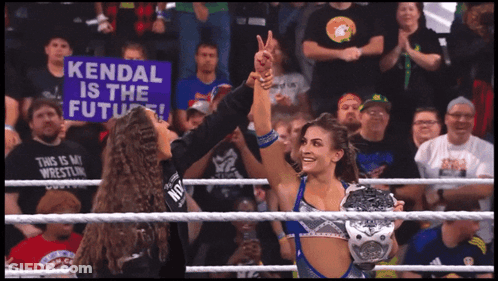 A Woman In A Wrestling Ring Holds A Sign That Says Kendal Is The Future GIF