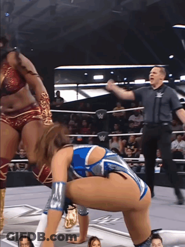 A Woman In A Wrestling Ring With A W Logo On The Wall GIF