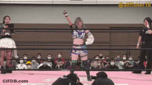 A Woman In A Wrestling Ring With The Number 18 On Her Sleeve GIF