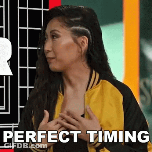 A Woman In A Yellow And Black Jacket With The Words Perfect Timing Below Her GIF